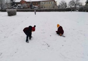 Dzieci lepią kule śniegowe