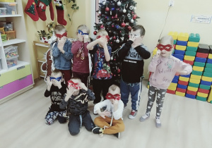 Dzieci w maskach karnawałowych przy choince