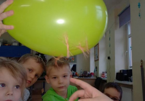 Dzieci sprawdzają czy przyczepione papierki nie odpadną od balona