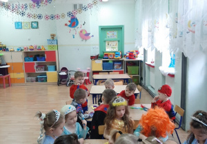 Dzieci przy stolikach robią maski