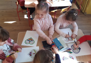 Dziewczynki malują serce wypełniając wzory mazakami