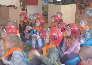 Dzieci słuchają wskazówek strażaka.