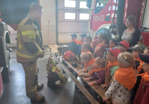 Strażak opowiada dzieciom jakim sprzętem posługuje się straż pożarna