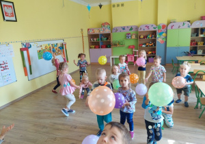 Dzieci przy muzyce bawią się balonami w kropki