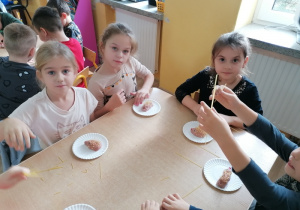 Dzieci wykonują jeże z ciastoliny.