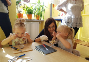 Dziewczynki ze smakiem zjadają sałatkę owocową