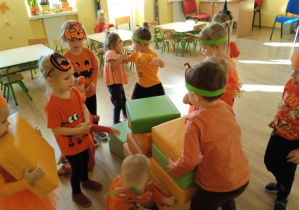 Dzieci układają dynie z żółtych i zielonych kostek
