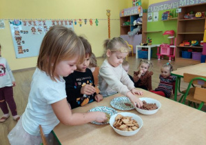 Dziewczynki próbują smaki miodów wykorzystując do tego ciastka