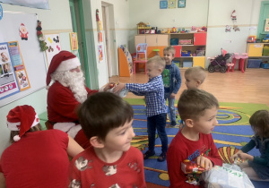 Mikołaj wręcza dzieciom prezenty