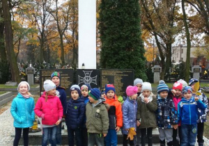 Dzieci przed pomnikiem na cmentarzu