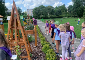 Dzieci spacerują ścieżką edukacyjną w ogrodzie