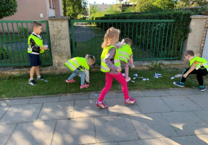 Dziewczynki i chłopcy zbierają śmieci