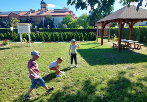 Grupa dzieci sprząta teren ścieżki edukacyjnej