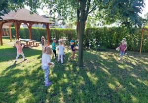 Grupa dzieci sprząta teren ścieżki edukacyjnej