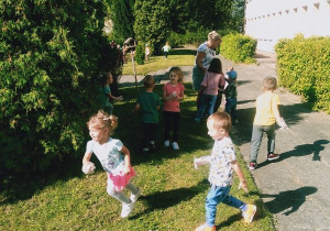 Dzieci sprzątają ogród przedszkolny.