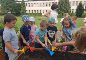 Dzieci zagrabiają ziemię