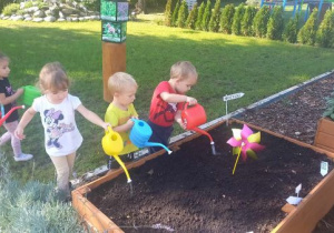 Dzieci podlewają cebulki kwiatowe