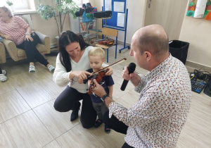 Dziecko próbuje grać na małych skrzypcach