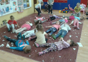 Dzieci leżą na dywanie 