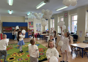 Dzieci bawią się białymi balonami