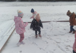 Dzieci robię ślady na śniegu.