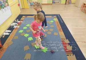 Dziewczynki chodzą po śladach dinozaura w poszukiwaniu