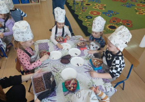 Dzieci dekorują czekoladowe serduszka