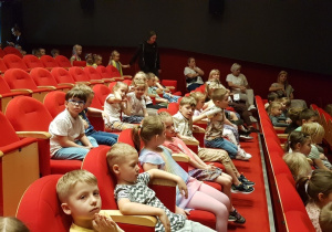Dzieci na widowni oczekują na rozpoczęcie spektaklu.