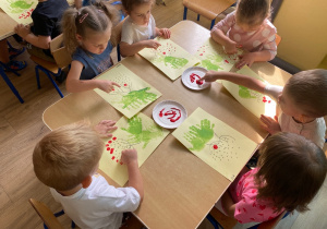 Dzieci stemplują palcami "korale jarzębiny".